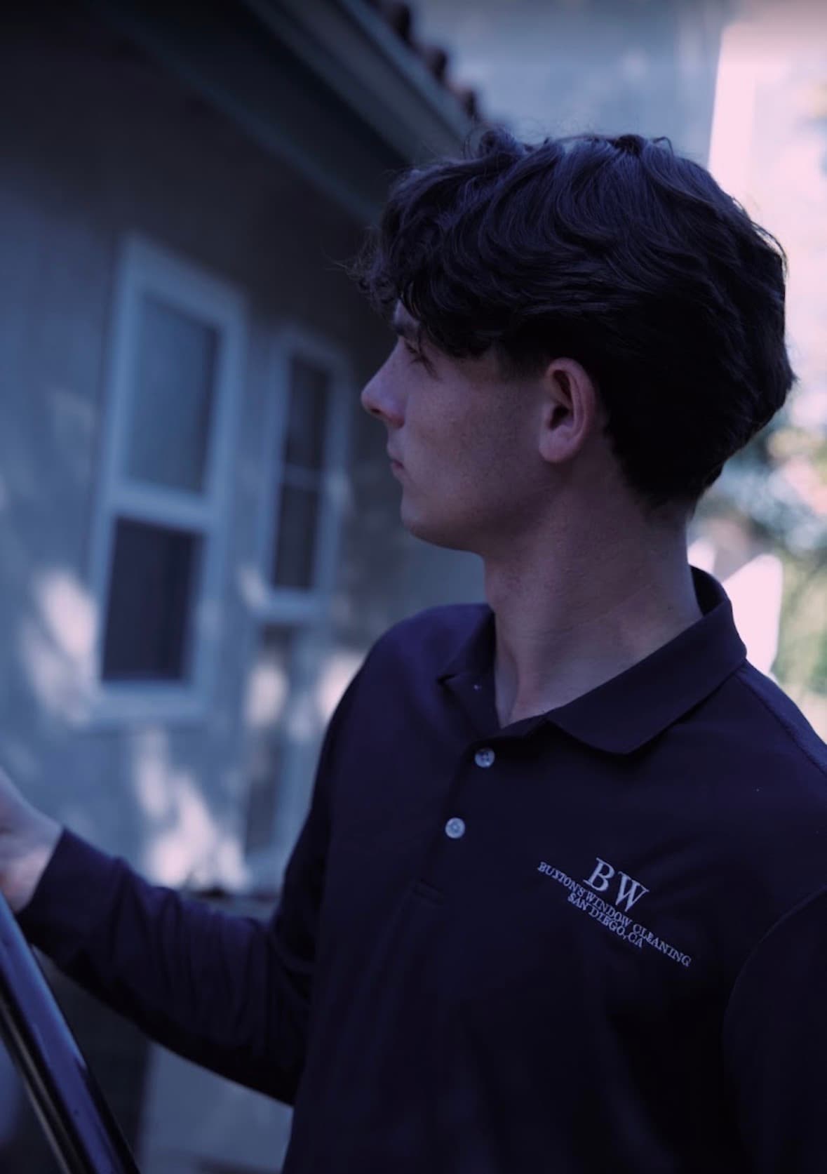 A Buxton Window Cleaning technician in uniform on a job in El Cajon
